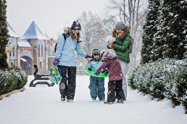 Attività invernali all'aperto per amici di famiglia amici di famiglia felici due donne due bambini e cane