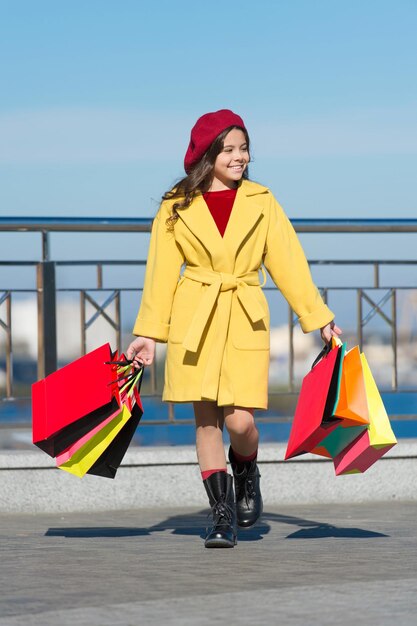 Attività quotidiana bambina con borse della spesa Attività per il tempo libero Tempo libero primaverile Moda per bambini Tendenza autunnale Bambino alla moda con berretto francese Giornata di shopping bambina felice che lascia lo showroom Tempo libero