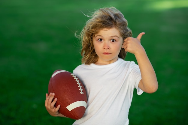 Attività sportive per bambini all'aperto gioco di calcio rugby football americano bambino ragazzo che gioca a calcio superarsi