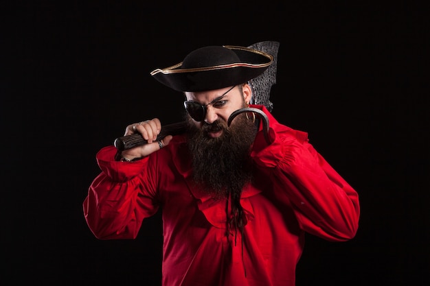 Attore maschio in costume da pirata e cappello da capitano per halloween. Bell'uomo barbuto vestito come un pirata caraibico per il carnevale.