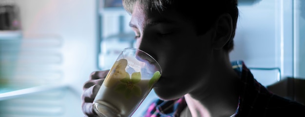 Attraente adolescente che beve latte fresco dal frigo durante la notte