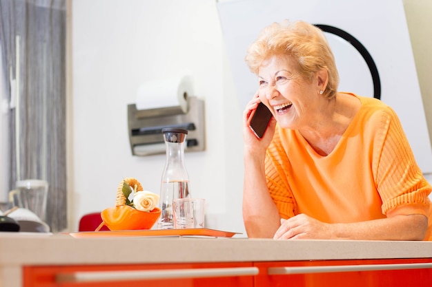 Attraente anziana donna spagnola sorridente a casa tua