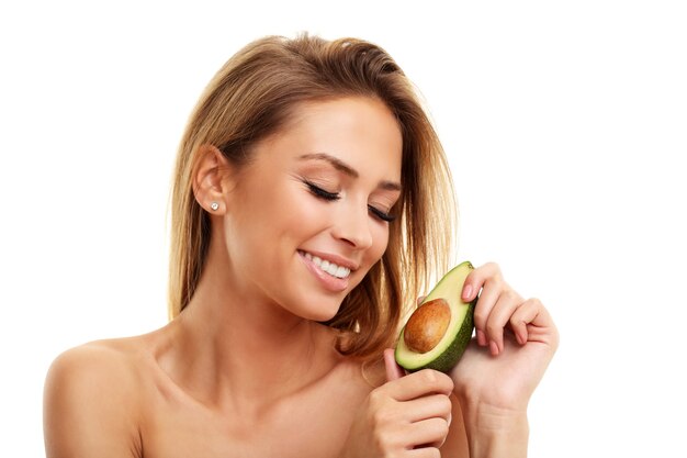 attraente donna adulta con avocado isolato su sfondo bianco