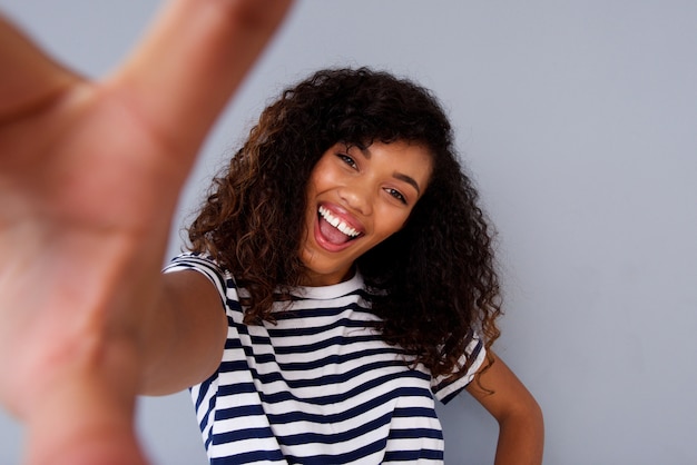 Attraente donna africana sorridente e prendendo selfie