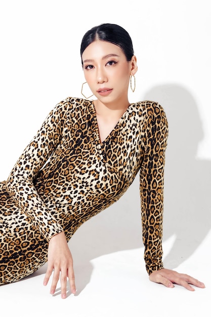Attraente donna asiatica ha una forma del corpo perfetta in collant con stampa leopardata su sfondo bianco