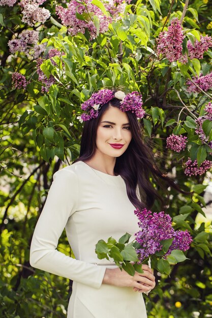 Attraente donna bruna all'aperto su sfondo floreale di primavera