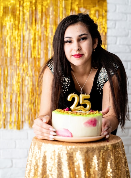 Attraente donna caucasica in abito da festa nero pronto a mangiare la torta di compleanno