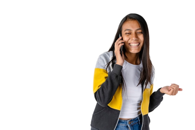 Attraente donna latina sorridente parlando al cellulare su sfondo bianco. Tecnologia e concetto di comunicazione.