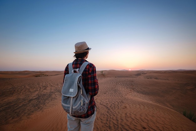 Attraente giovane donna asiatica in camicia a quadri nel deserto