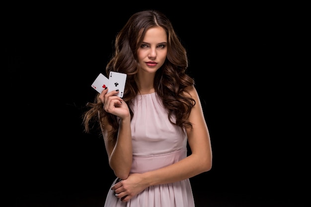 Attraente giovane donna che tiene la combinazione vincente di carte da poker