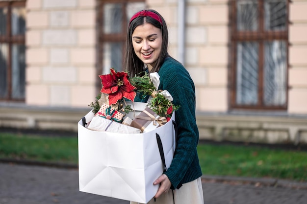 Attraente giovane donna con scatole regalo di Natale al di fuori dello spazio della copia