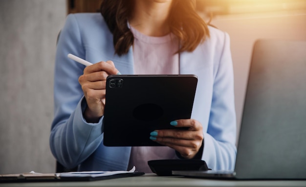 Attraente giovane donna d'affari asiatica sorridente lavora a casa ufficio Donna asiatica che lavora su computer portatile azienda tablet