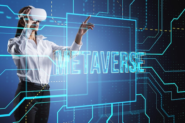 Attraente giovane donna d'affari con occhiali VR utilizzando l'ologramma di testo metaverse incandescente su sfondo tecnologico sfocato Mondo digitale e concetto futuro Doppia esposizione