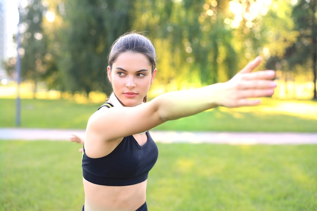 Attraente giovane donna fitness che si esercita all'aperto, esercizi di stretching.