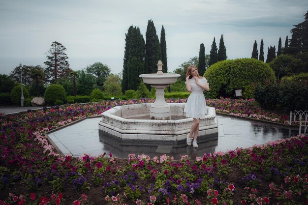 Attraente giovane donna godendo il suo tempo fuori nel parco Bellissimo palazzo verdi succosi dopo una pioggia in primavera