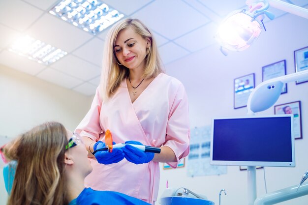 Attraente giovane donna in stomatologia clinica con allegro dentista femminile.