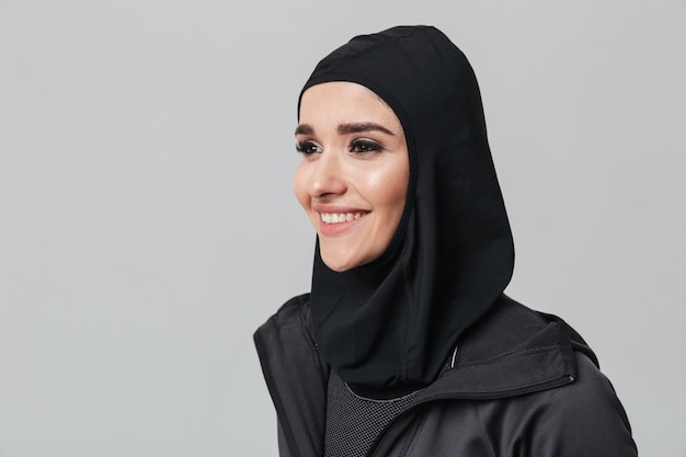 Attraente giovane donna musulmana che indossa l'hijab sportivo isolato