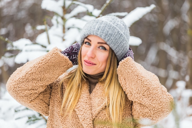 Attraente giovane donna nell'orario invernale all'aperto. Concetto di neve, vacanze e stagione.