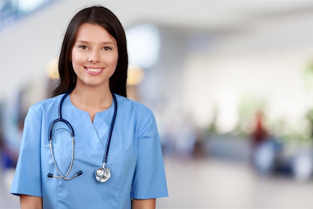 Attraente giovane dottoressa con ospedale sfocato