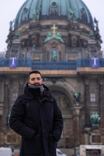 Attraente giovane turista maschio con la barba e la cattedrale di Berlino sullo sfondo