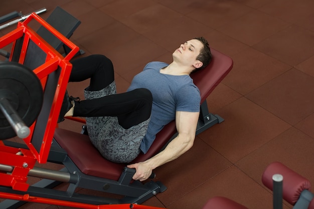 Attraente Giovane Uomo Facendo Leg Press Sulla Macchina In Palestra