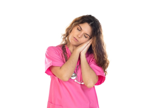 Attraente medico che indossa una divisa rosa isolata su uno sfondo bianco