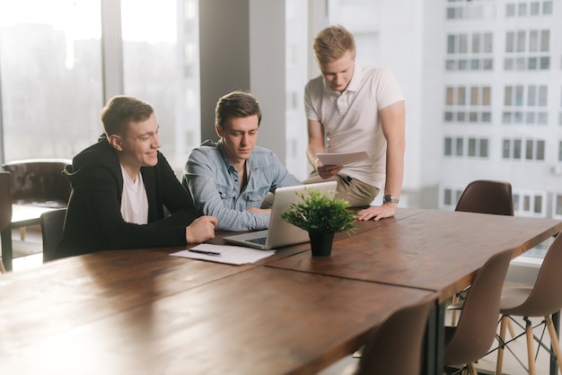 Attraente millennial giovani uomini business team di brainstorming al tavolo