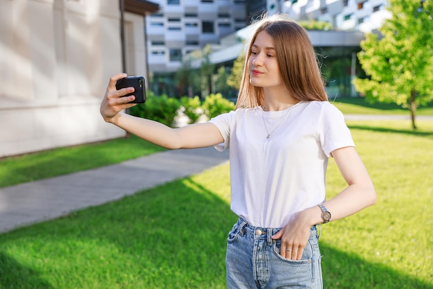 Attraente ragazza in posa prendendo selfie sul cellulare durante la pausa all'università affascinante