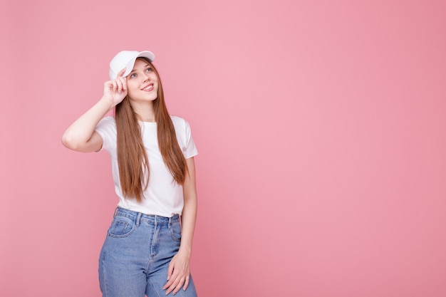Attraente ragazza in un berretto su uno sfondo rosa