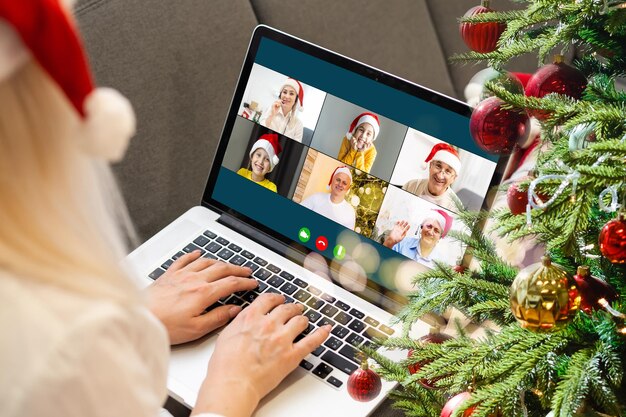 Attraente studentessa felice che ha video chat, agitando. Natale