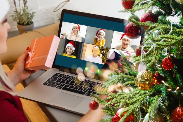 Attraente studentessa felice che ha video chat, agitando. Natale