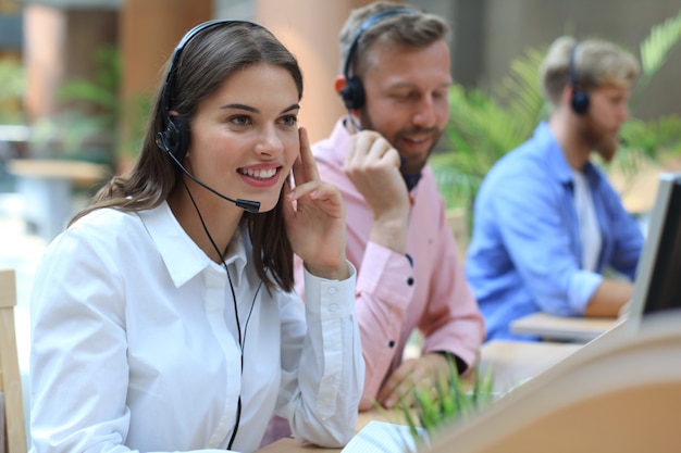 Attraenti giovani imprenditori e colleghi positivi in un ufficio di call center.