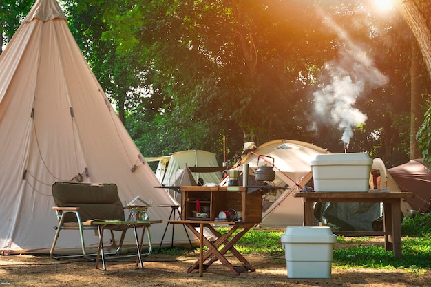 Attrezzatura da cucina all'aperto e tavolo in legno con gruppo di tende da campo nell'area campeggio