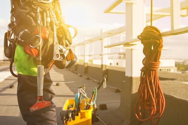 Attrezzatura del lavoratore alpinista industriale sul tetto dell'edificio durante il lavoro di grattacielo dell'industria Attrezzature per arrampicata prima di iniziare il lavoro