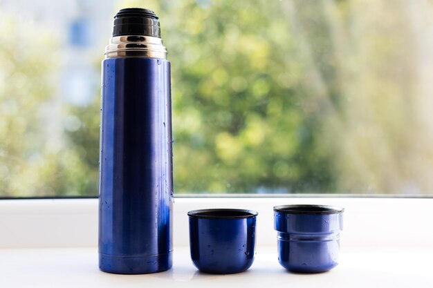 Attrezzatura di thermos blu con coperchi.