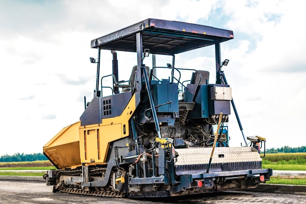 Attrezzature per pavimentazione in asfalto. Asfaltatrice e rullo vibrante pesante. Costruzione di nuove strade e svincoli stradali. Macchinari industriali per costruzioni pesanti.