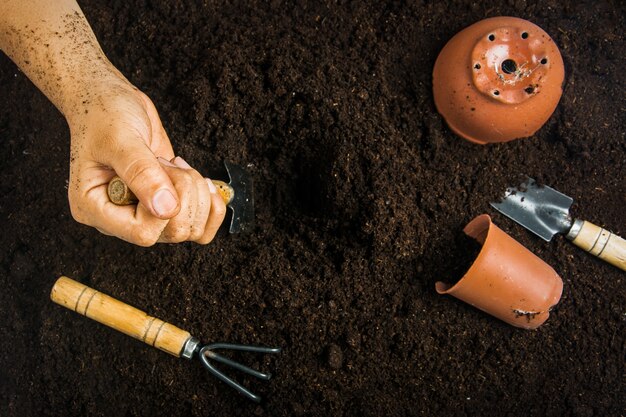 Attrezzi da giardinaggio e mano con terreno