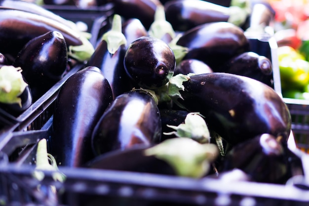 Aubergine viola fresche su un bancone del mercato di strada in Italia