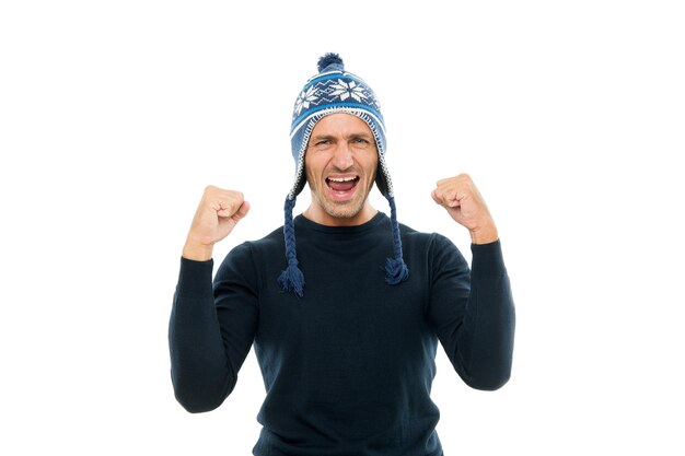 Auguri. Ragazzo indossa un cappello invernale. Buon Natale e Felice Anno nuovo. Vacanze invernali. Uomo maturo in setola del fronte del cappello. Emozioni positive. L'uomo bello celebra il fondo bianco di vacanze invernali.