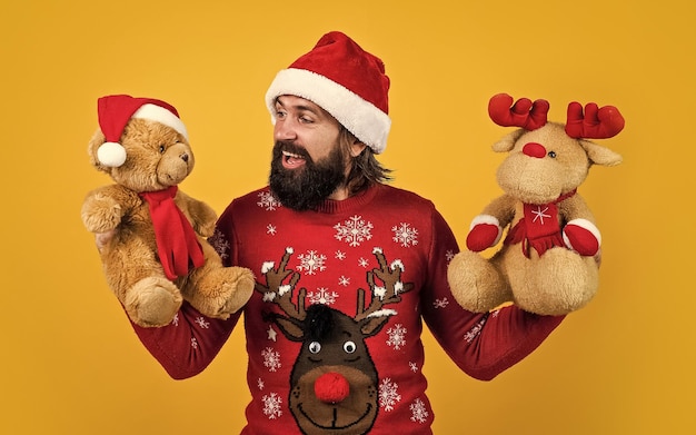 Auguro buon natale uomo barbuto in costume da babbo natale hipster festeggia la festa di natale con renne e orso giocattolo preparazioni per le vacanze invernali presente e vendita di regali felice anno nuovo