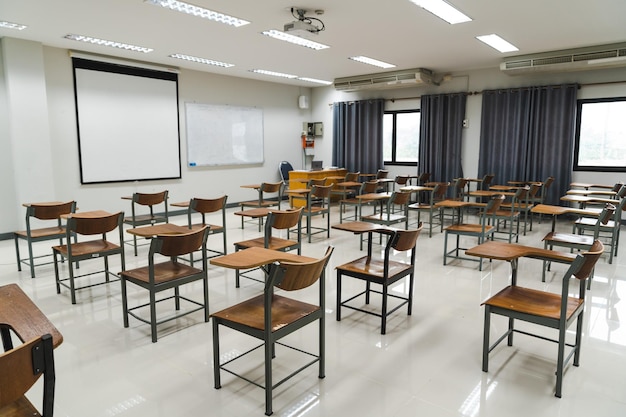 Aula scolastica con molte sedie di legno ben disposte in file senza studenti