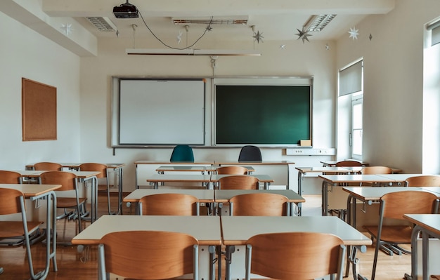 Aula scolastica vuota con lavagna verde.