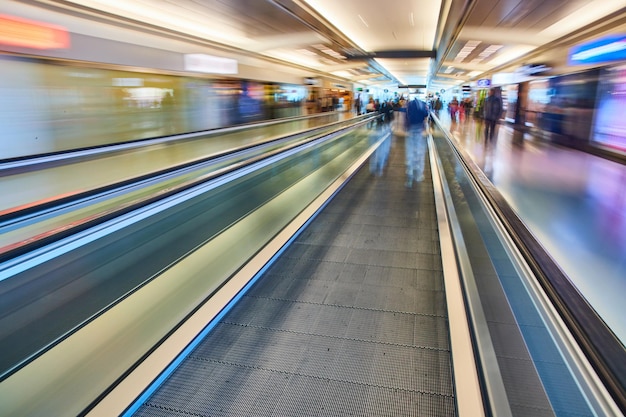 Aumentare la velocità sfocata dalla passerella in movimento con le persone che passano