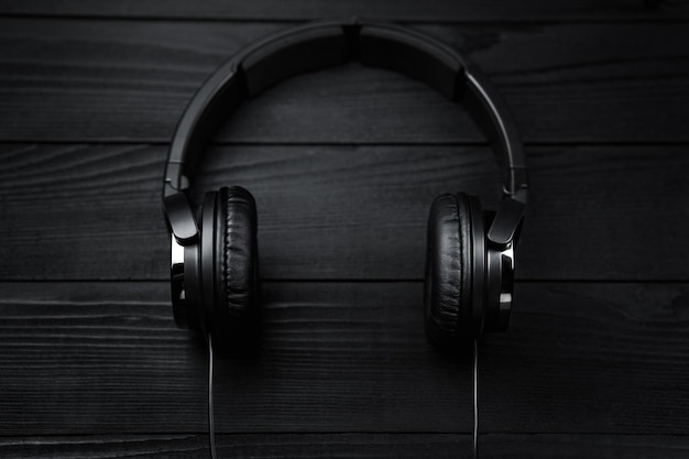 Auricolari neri su sfondo nero di legno scuro