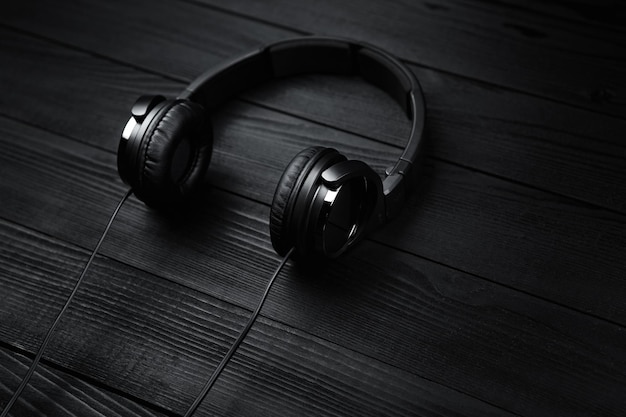 Auricolari neri su sfondo nero di legno scuro