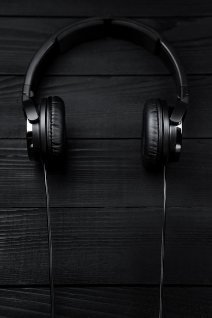 Auricolari neri su sfondo nero di legno scuro