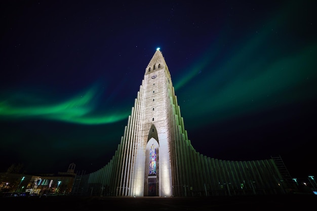 Aurora boreale che splende sopra la chiesa di Reykjavik in Islanda