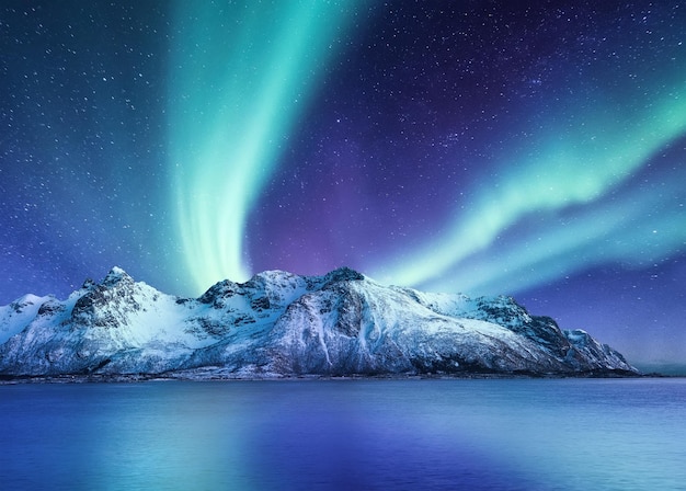 Aurora Boreale Isole Lofoten in Norvegia Montagne delle luci del nord e riflessione sull'acqua Paesaggio invernale durante le luci polari Immagine di viaggio in Norvegia