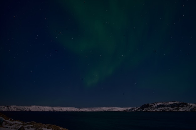 Aurora boreale sul campo silenzioso prima dell'alba