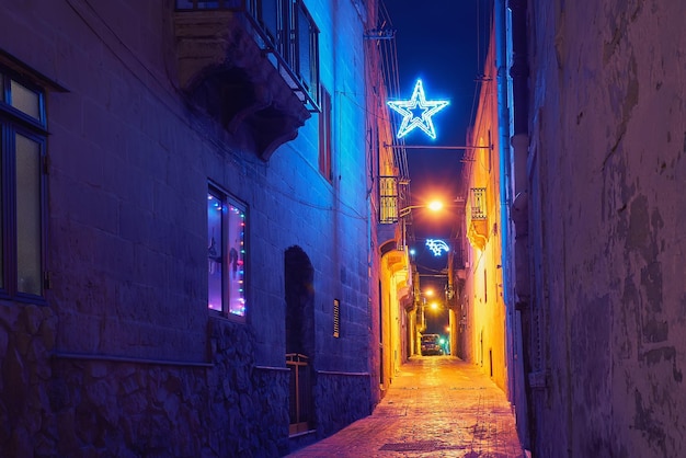 Autentica stradina della città vecchia di Malta nell'arredamento e nelle luminarie natalizie, nella stella di Natale e nelle luci.